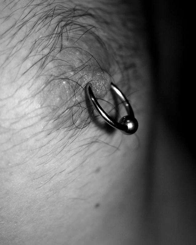 Brystpiercing med guldfarvet smykke