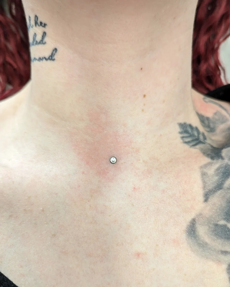 Dermal piercing med lille sten på brystet